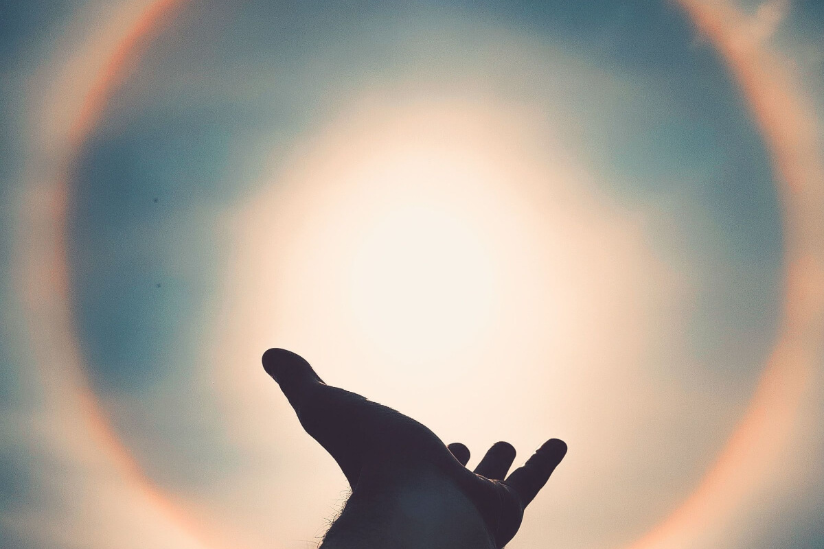a hand reaching towards light showing spirituality