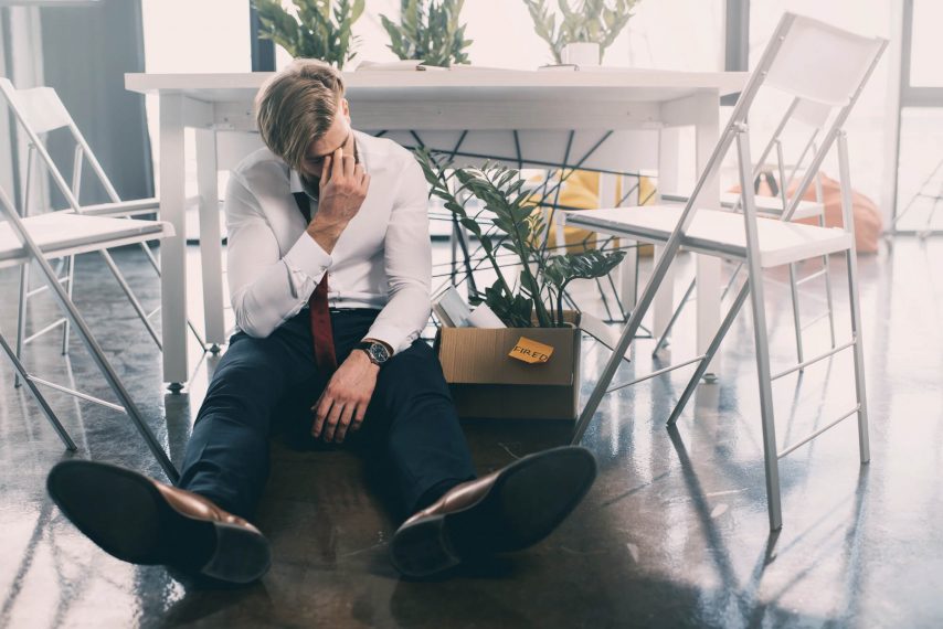 white guy sitting on floor holding his head looking in crisis as he doesn't know about online counseling as a solution