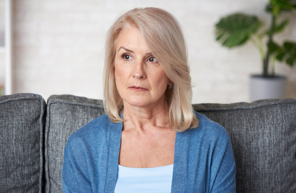 blond haired middle aged female staring off intensely thinking presumably about being overly attached to her therapist