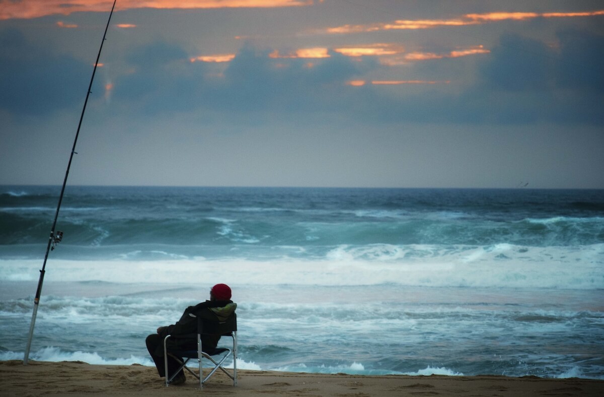 person in lounge chair facing stormy seas