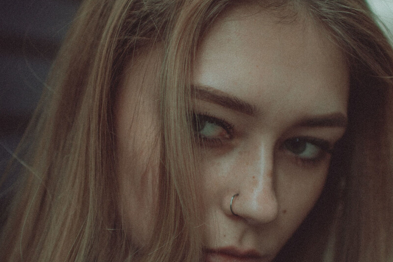 young blond haired white female looking askance